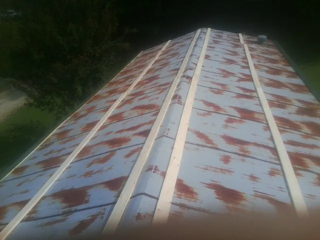 Rusted metal roof panels with new wood purlins before replacement — Storm Damage Roof Repair in Nancy by Roofing Brothers
