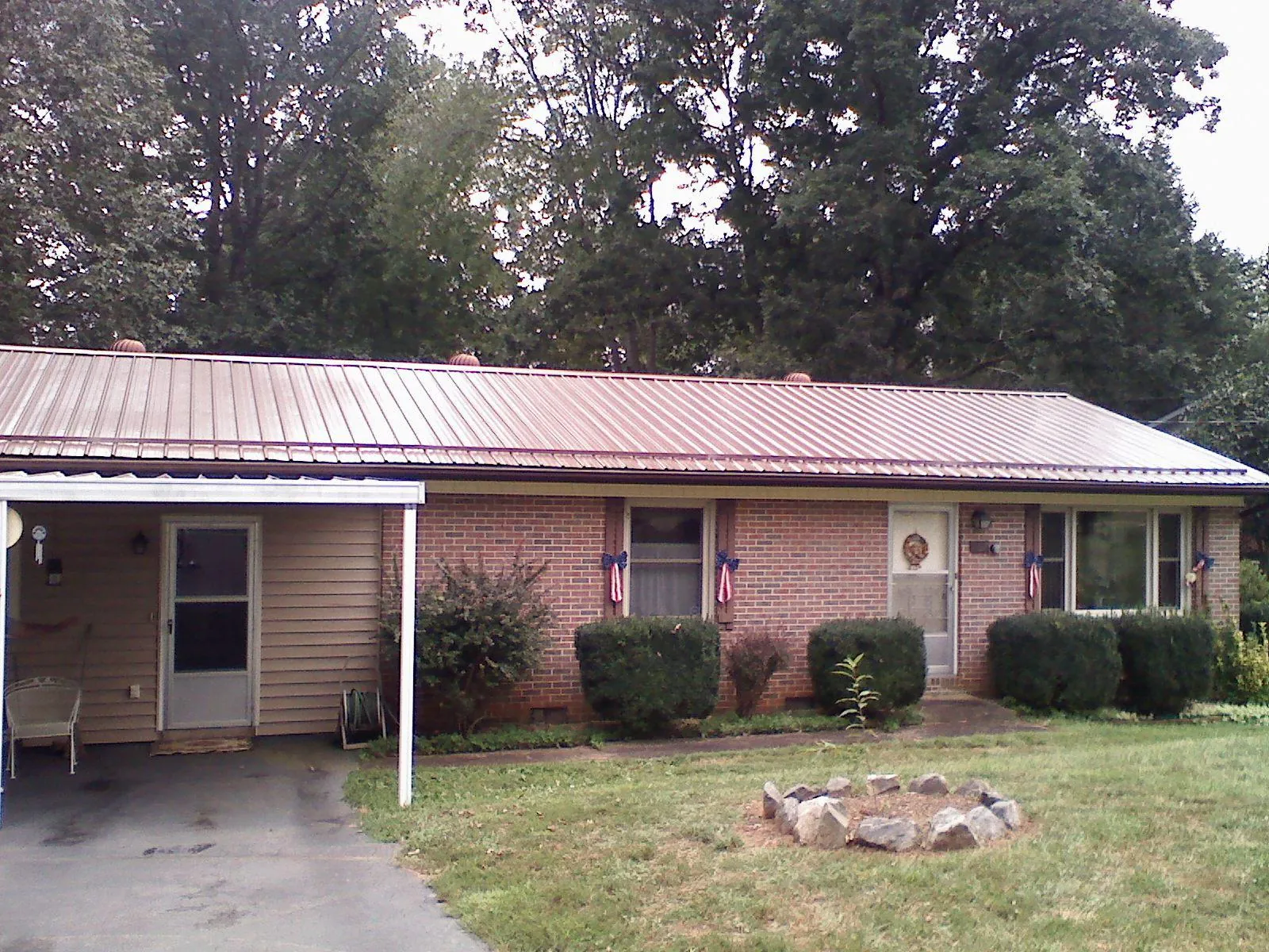 Bronze metal roof and carport on a brick ranch home — Roof Repair work by our crew in Nancy
